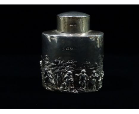A silver tea caddy repousse decoration with village life scenes, Chester 1899, height 8cm, weight 2.5oz approximately.