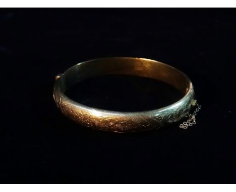 A 9ct gold hinged hollow bangle with engraved decoration, weight 13.2g approximately.