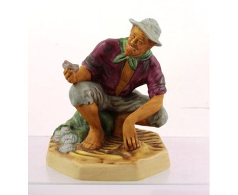 A ROYAL DOULTON EARTHENWARE FIGURINE "BEACHCOMBER", a smiling man crouching holding a shell, matt finish, ref. HN2487, 17cm h