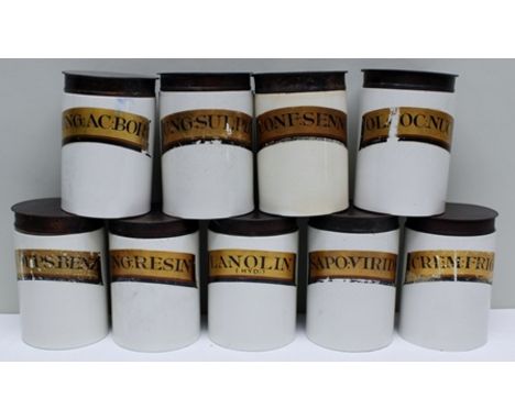A COLLECTION OF NINE EARLY 20TH CENTURY GLAZED POTTERY CHEMIST JARS, with gilded panel, script titles, each with a tin cover,