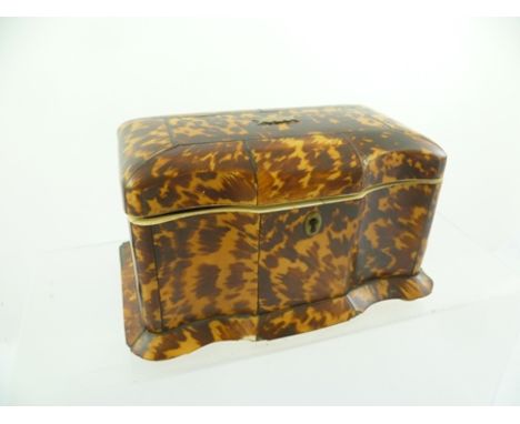 AN EARLY 19TH CENTURY TORTOISESHELL TEA CADDY of serpentine breakfront form, the hinged lid enclosing two inner lidded compar