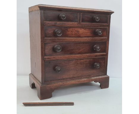 19th century mahogany miniature chest of drawers, the rectangular top with applied moulded edge, above two short and three lo