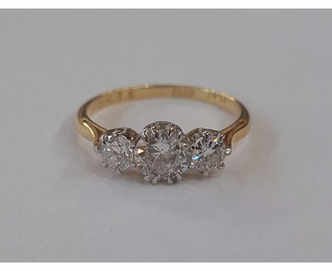 Gold graduated three stone diamond ring, marked 18ct, the central brilliant cut diamond measuring approx. 5.7mm dia. and 3.1m