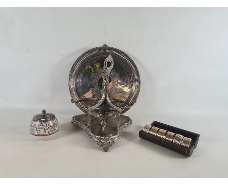 Cased set of six silver plated napkin rings in cylindrical case, wavy engraved decoration with shield monogram, an inscribed 