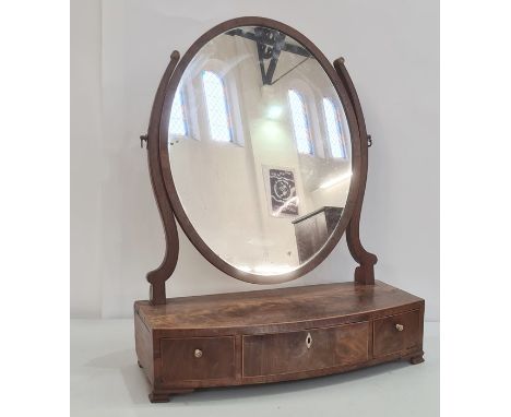 19th century mahogany oval swing toilet mirror, the bowfront base with three drawers, to ogee bracket feet