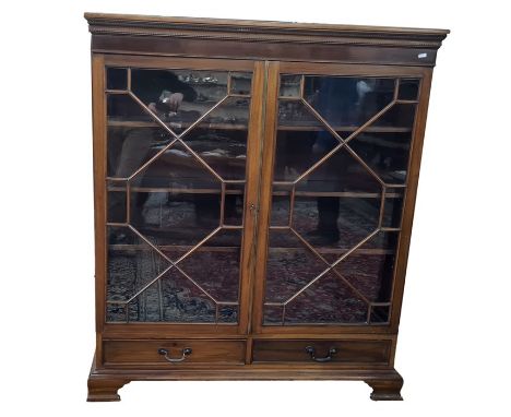 Early 20th century mahogany glazed bookcase having stiffleaf and beaded borders to the pediment, fitted three shelves enclose