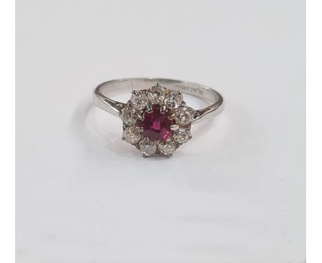 Platinum, ruby and diamond cluster ring set central circular ruby surrounded by nine diamonds, marked Platinum, ring size K/L