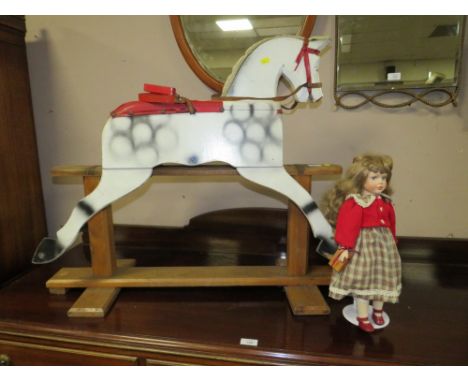 A VINTAGE NAIVE ROCKING HORSE ON A TRESTLE BASE - IN NEED OF RESTORATION AND A DOLL (2)