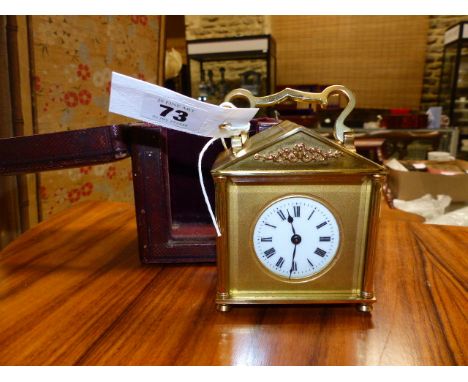 A SMALL EARLY 20th.C.BRASS CASED CARRIAGE CLOCK WITH TWIN ESCAPMENT WINDOW TO PEDIMENT TOP COMPLETE WITH ORIGINAL LEATHER OUT