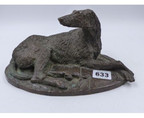 A PATINATED BRONZE FIGURE OF A RECUMBENT IRISH WOLF HOUND.    W.23cms.