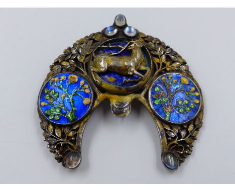 AN ARTS AND CRAFT WHITE METAL AND ENAMELLED BROOCH. ORIGINALLY A HAIRSLIDE, THE CENTRE PANEL WITH RELIEF LEAPING STAG BACKED 