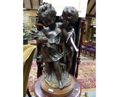 A BRONZE FIGURAL GROUP OF TWO CHILDREN INDISTINCTLY SIGNED ON OAK BASE.    OVER ALL H.42cms.