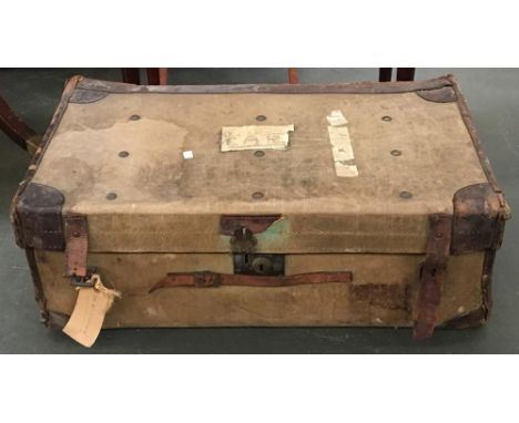 A vintage canvas travel trunk with leather corner bracings 