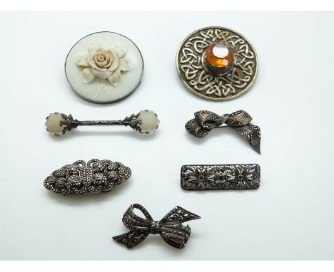 Two silver brooches set with marcasite in the form of bows, a white metal brooch in the form of thistles set with agate, marc