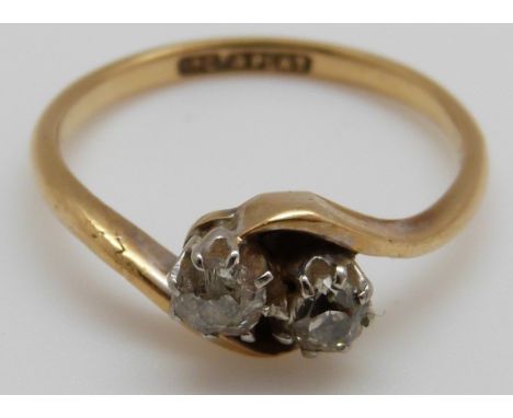 An 18ct gold ring set with two diamonds in a twist setting, 3g (size O)