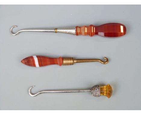 A hallmarked silver and Scottish thistle button hook together with two banded agate handled examples