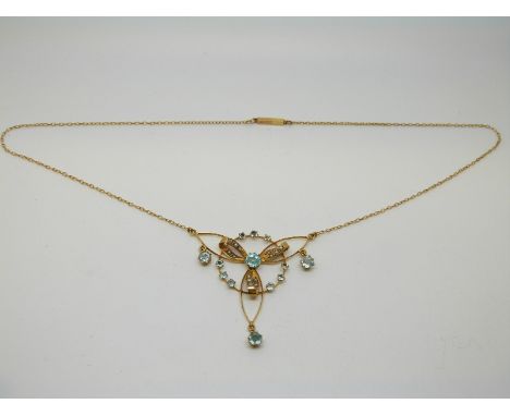 A 9ct gold Edwardian necklace set with aquamarines and seed pearls in a stylised bow design