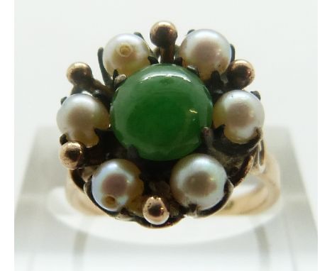 A 14k gold ring set with a jade cabochon surrounded by pearls, size K, 4.56g