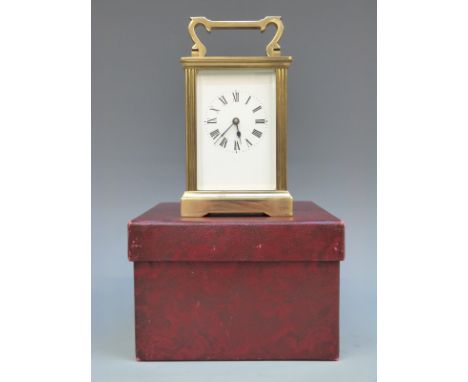 A French style mid to late 20thC brass carriage clock with reeded decoration to square corners. The white enamel Roman dial w
