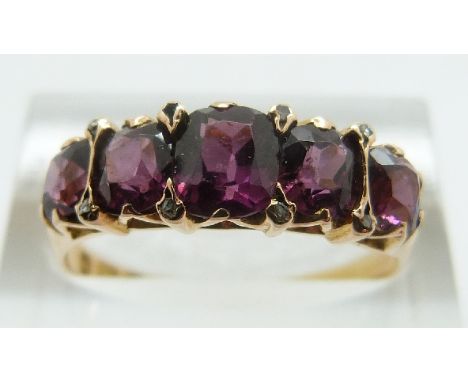 A 15ct gold ring set with five graduated garnets and diamonds (Birmingham 1873), size R/S, 3.22g 