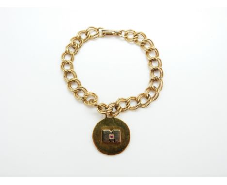 A yellow metal pendant/charm set with a ruby (5.9g) on a bracelet 