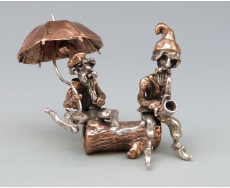 A novelty part white metal figure group of two bearded men, one with umbrella the other a pipe, marked to legs with star and 