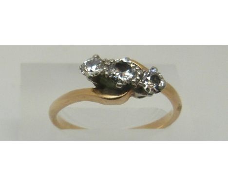 An 18ct gold ring set with three diamonds in a platinum twist setting, the largest diamond approximately 0.3ct, size Q/R, 3.1