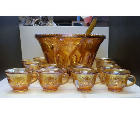 A carnival glass pedestal punch bowl set with cups, ladle and hangers, 30cm diameter