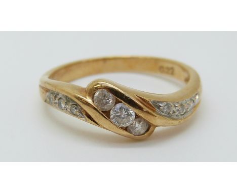 An 18ct gold ring set with diamonds totalling approximately 0.22ct in a twist setting, 2.82g (size K) 