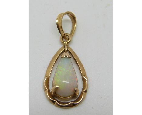 A 14k gold pendant set with a pear cut opal cabochon