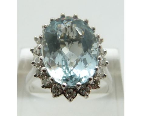 An 18ct white gold ring set with a central oval mixed cut aquamarine of approximately 2ct in a diamond set surround, size R/S