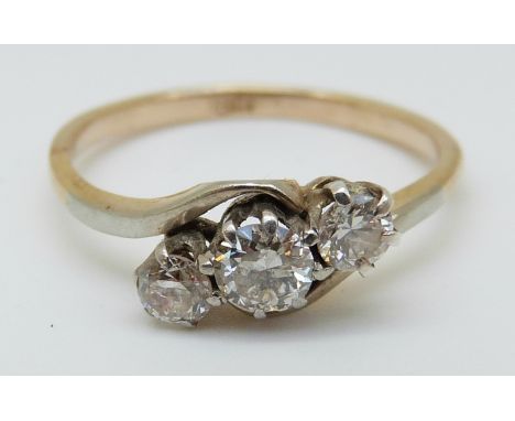 An 18ct gold ring set with three diamonds in a platinum setting, 1.64g (Size M)