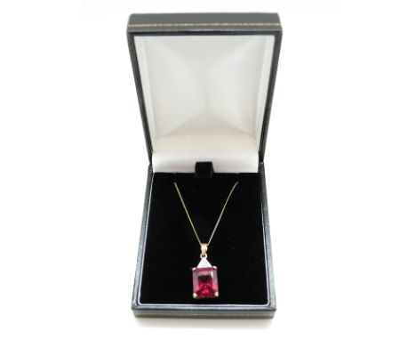 A 9ct gold pendant set with an emerald cut synthetic ruby and diamonds