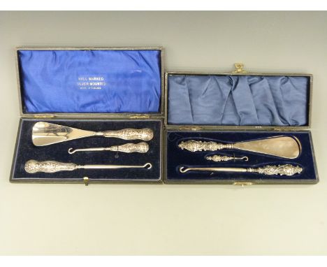 A cased hallmarked silver handled button hook / shoe horn set and another set with Art Nouveau style plated handles