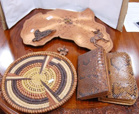 Wall clock modelled as a map of Africa, two snakeskin clutch bags and a wicker wall hanging modelled as a targe. 