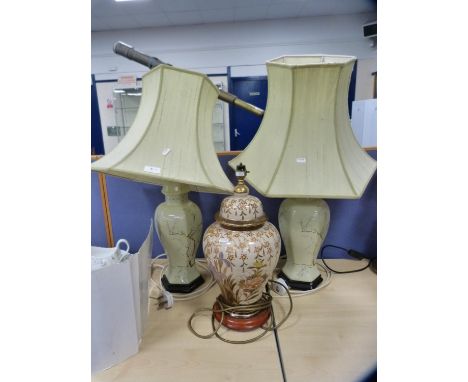 Pair of Chinese-style ceramic table lamps decorated with prunus blossom, with shades, and another table lamp. 