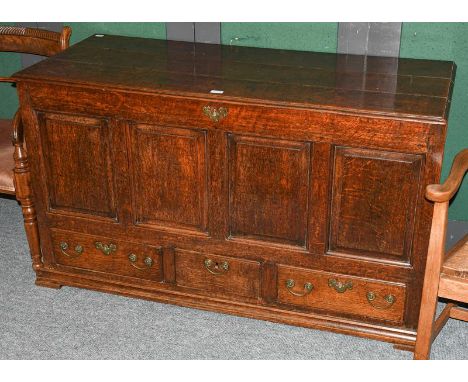 An 18th century oak four panelled mule chest with three plank top, with three drawers and raised on shallow bracket feet, 140