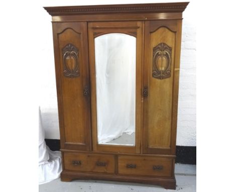 ART NOUVEAU MAHOGANY WARDROBE with a moulded dentil cornice above a shaped central bevelled mirror door flanked by panelled d