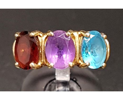 AMETHYST, GARNET AND BLUE TOPAZ THREE STONE RINGthe three oval cut gemstones on ten carat gold shank, ring size N 