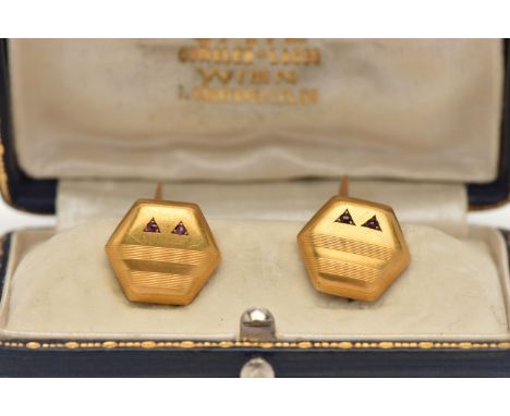 A PAIR OF YELLOW METAL GEM SET CUFFLINKS, hexagon form cufflinks, with engine turned pattern, two circular cut garnets set in