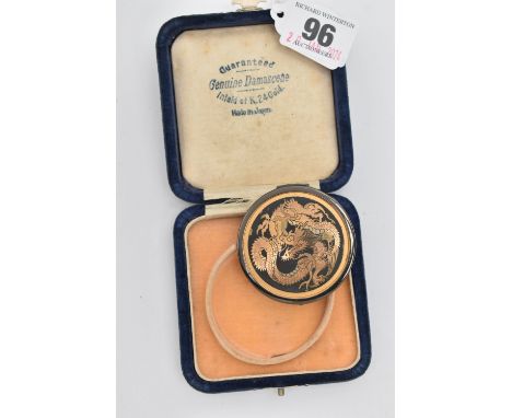 A BOXED 'DAMASCENE' COMPACT, of circular form featuring an oriental dragon, boxed signed inside 'Guaranteed Genuine Damascene
