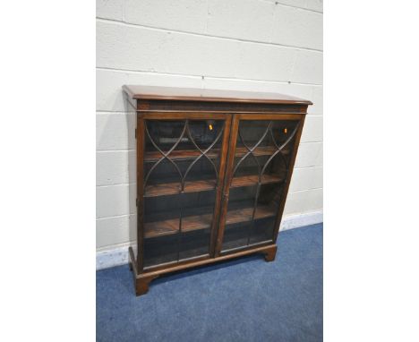 AN EDWARDIAN MAHOGANY BOOKCASE, the double astragal glazed doors enclosing three adjustable shelves, on bracket feet, width 1