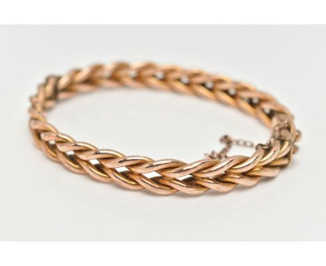 A YELLOW METAL HINGED BANGLE, plait design with applied bead work, push piece integrated box clasp with additional safety cha