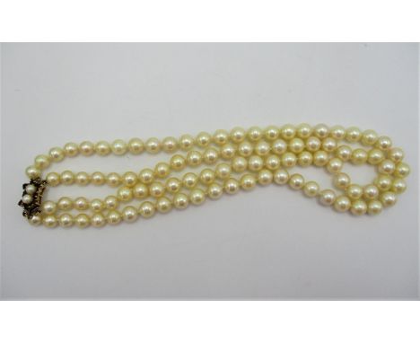 A double stranded cultured pearl necklace with 9ct gold clasp inset with garnets, 43 cm long 