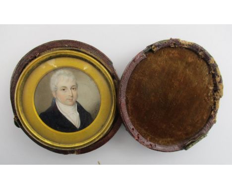 A British miniature portrait of a gentleman on ivory, English School, 19th century, of circular form within a brass glazed fr