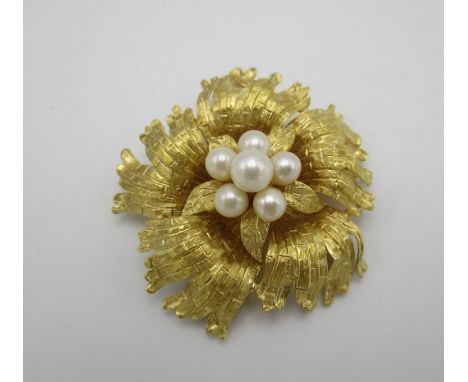 An 18 ct gold and pearl brooch, modelled as a flower with textured detail to the petals, set with a cluster of six cultured p