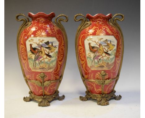 Pair of reproduction ceramic vases having panels of exotic birds against a red scroll ground with gilt metal mounts, 31cm hig