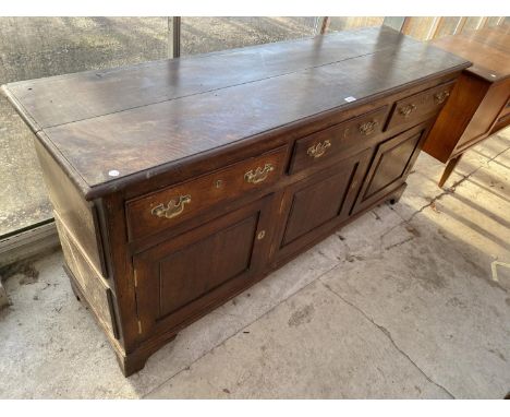 A GEORGE III OAK DRESSER BASE ENCLOSING THREE FRIEZE DRAWERS, THREE PANELLED CUPBOARDS, ON BRACKET FEET, 65" WIDE 