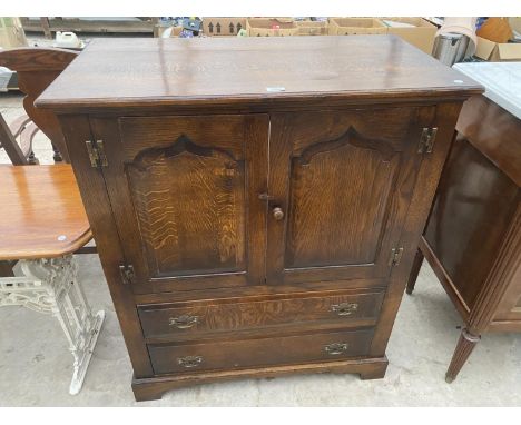 A REPRODUCTION OAK TV/VIDEO CABINET WITH PANELLED DOORS, 37" WIDE 