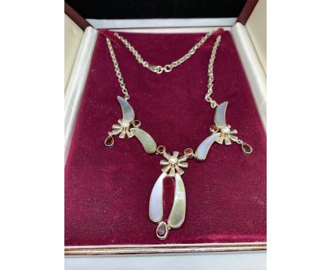 A DECORATIVE SILVER NECKLACE WITH RED AND PEARL COLOURED STONES IN A PRESENTATION BOX 